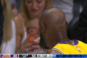 抓紧拍下来!詹姆斯在场边咬牙套调整 场边女球迷拿起手机拍摄